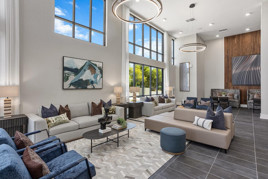 A modern living room with a large window and a painting on the wall.