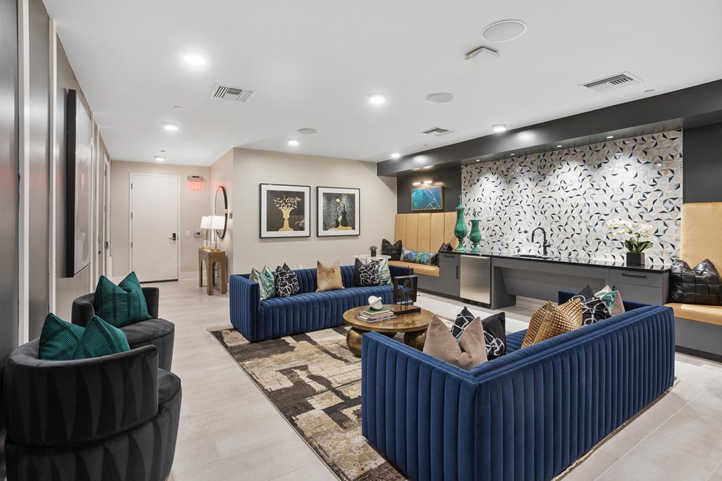 A living room with a blue couch and a patterned wallpaper.