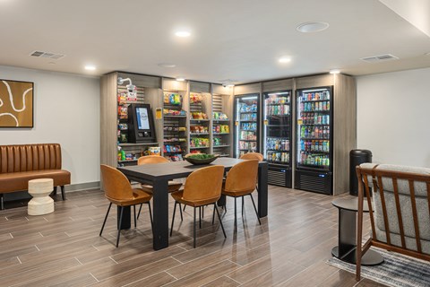 A modern dining area with a table set for four, a bench, and a vending machine.