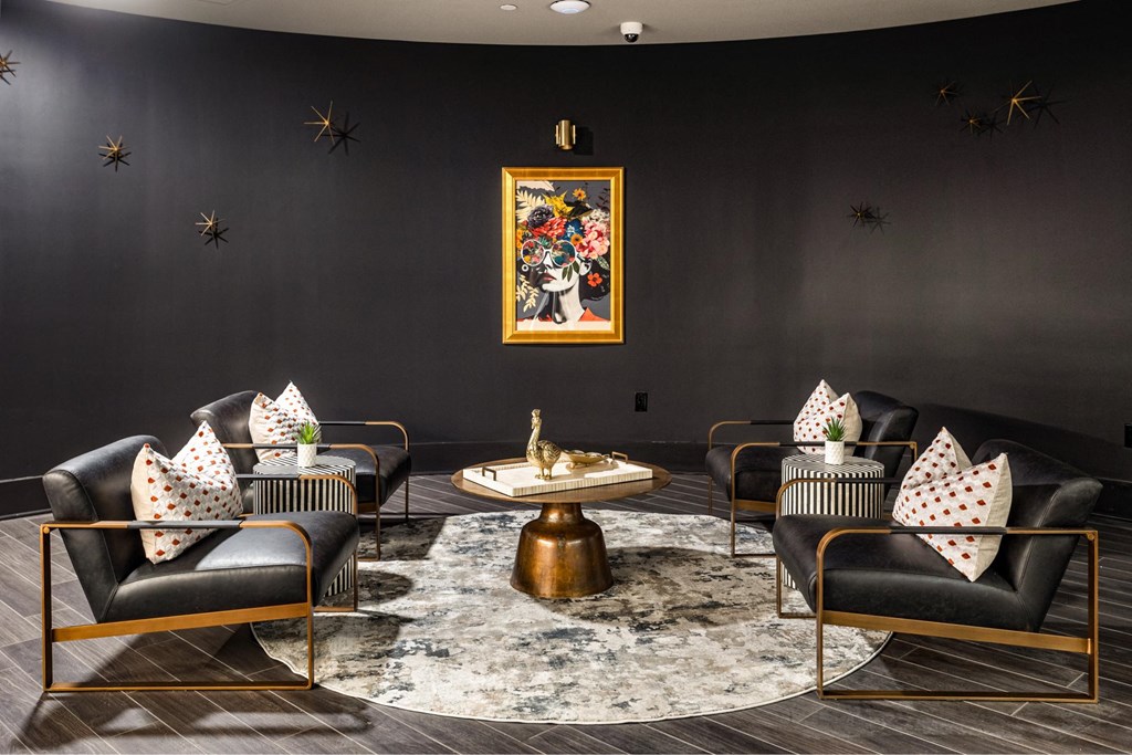 A living room with black walls and a large painting above a coffee table.