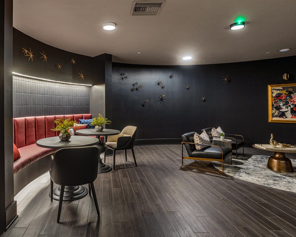 A modern living room with a curved wall, a sofa, a chair, a table, and a painting on the wall.