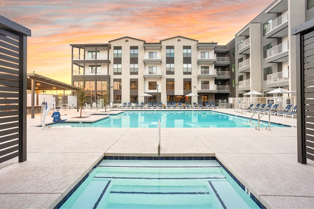 A large swimming pool in front of apartment buildings.