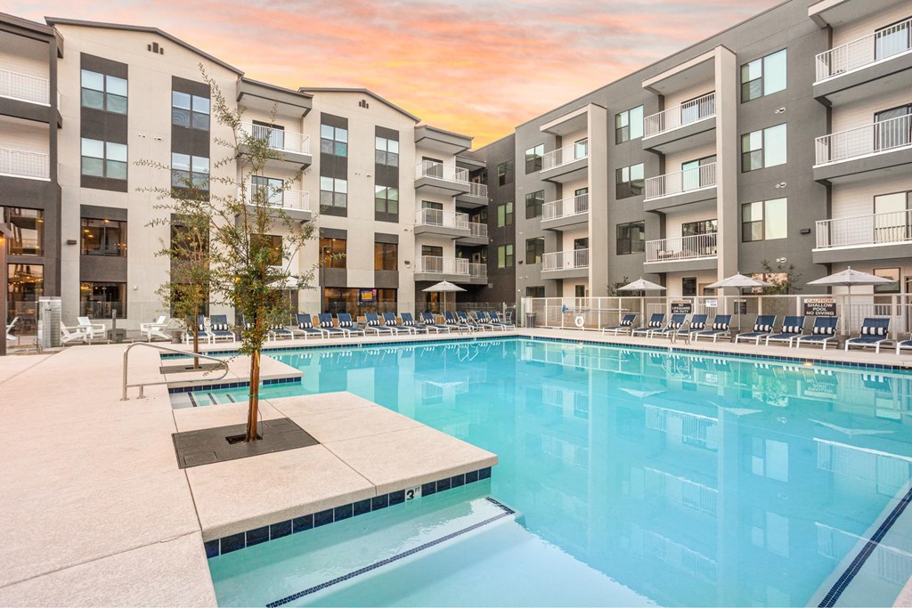 A large swimming pool in front of apartment buildings.