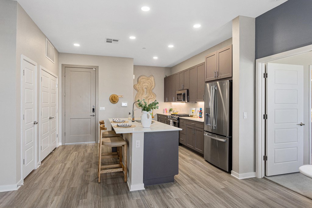 a kitchen with a large island and stainless steel appliances