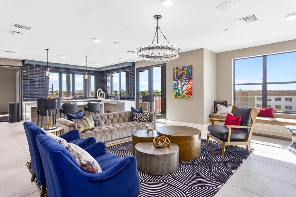 a living room with blue couches and chairs and a large window