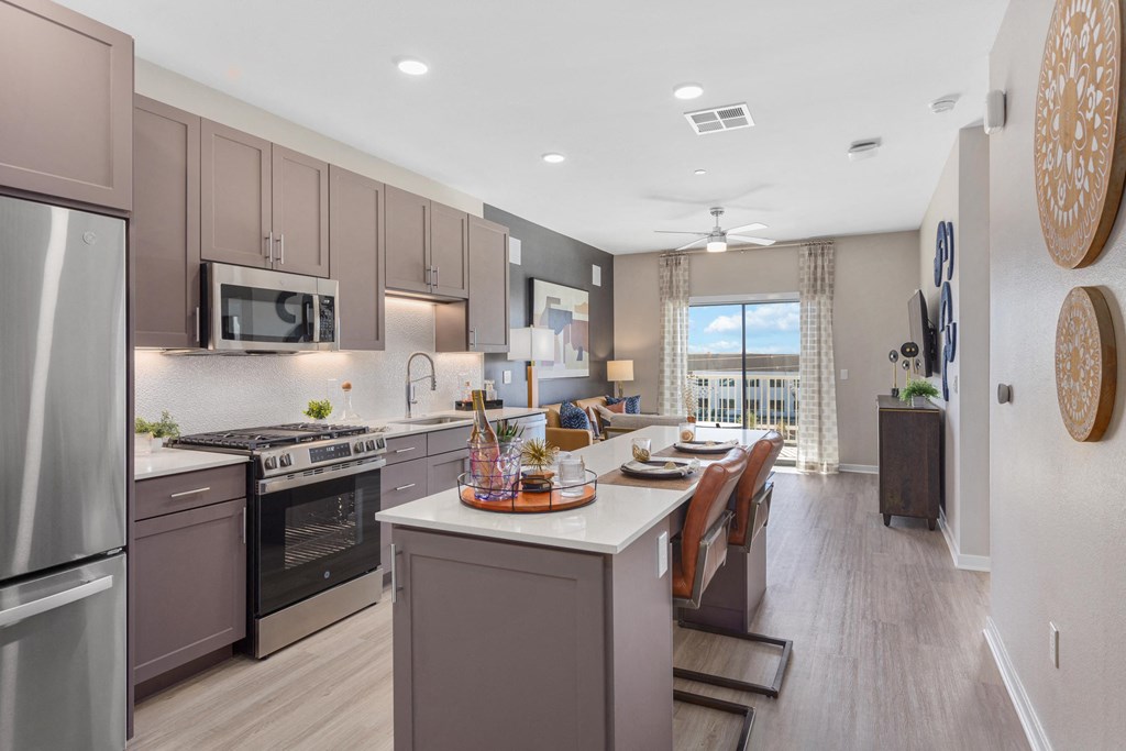 a kitchen and dining room with stainless steel appliances and wooden floors