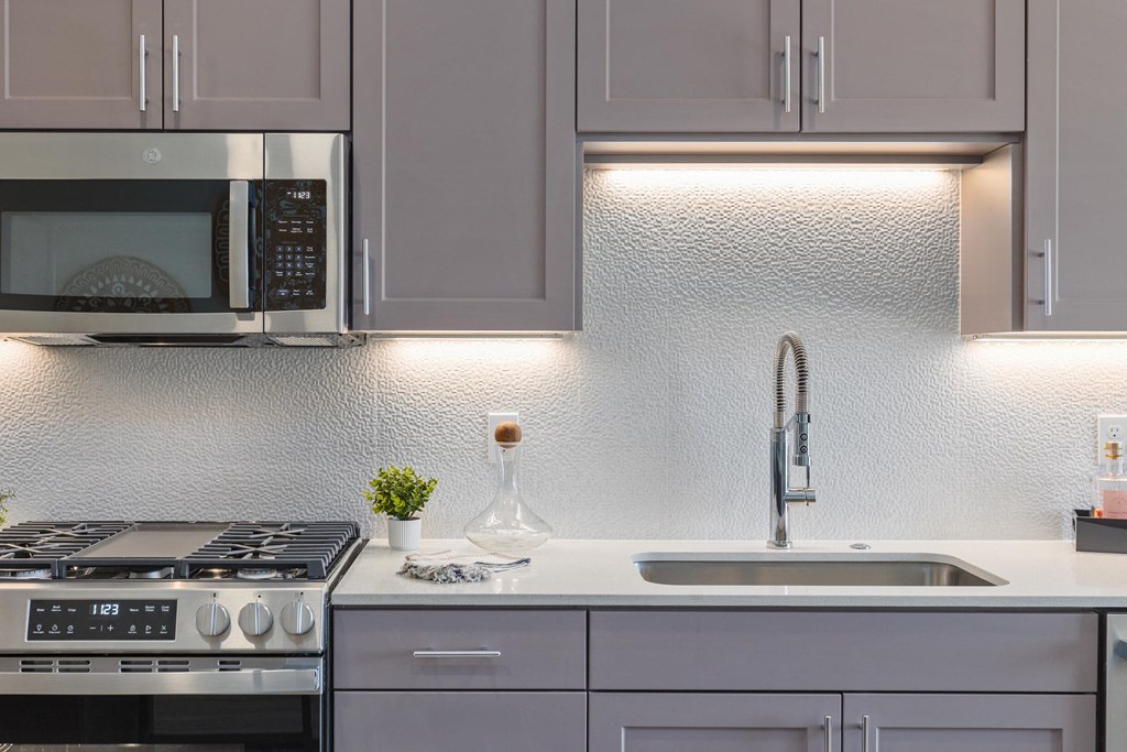 a kitchen with white cabinets and a sink and a microwave