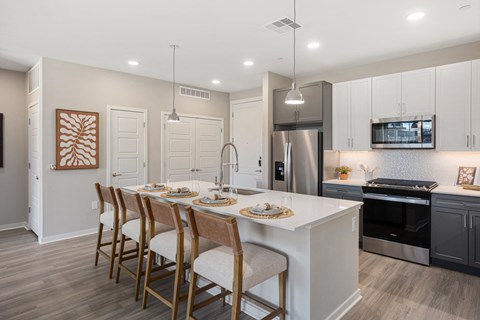 A modern kitchen with a dining table set for four.