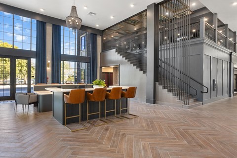 A modern kitchen with a bar and a staircase.