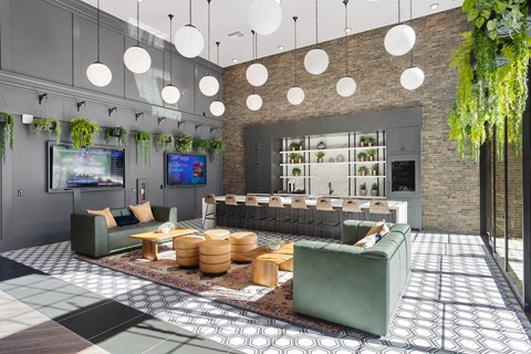 A modern living room with a green couch and a TV on the wall.
