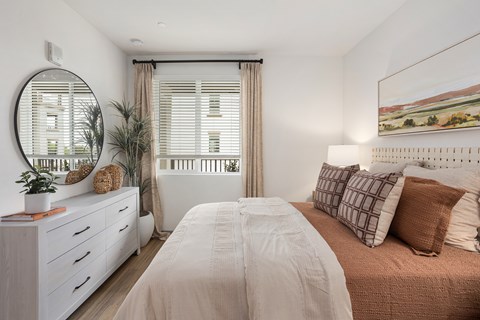 A bedroom with a large bed and a mirror on the wall.
