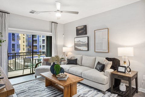 A living room with a couch, a table, and a ceiling fan.