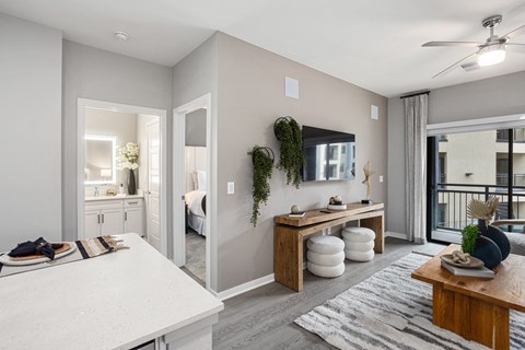 A modern living room with a kitchen area in the background.