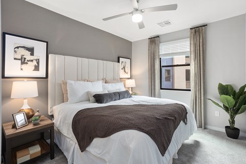A bedroom with a large bed and a ceiling fan.