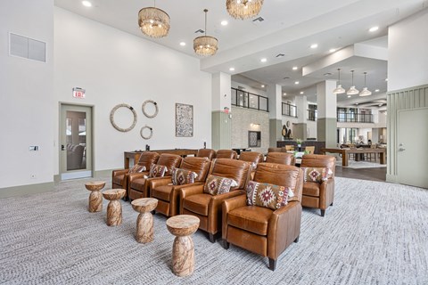 A living room with brown leather furniture and a grey carpet.