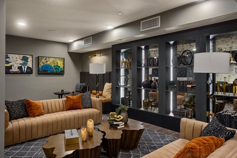 A modern living room with a large sofa, a coffee table, and a bookshelf filled with books.