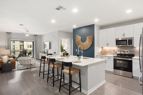 A modern kitchen with a white island and stools.