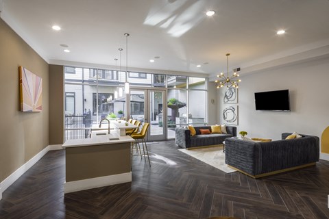 a living room with couches and chairs and a kitchen with a breakfast bar