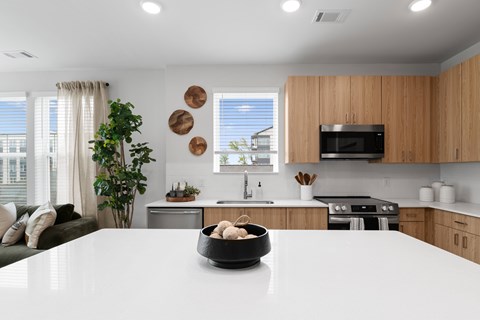 A modern kitchen with wooden cabinets and a white countertop.
