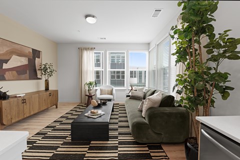 A living room with a green couch, a coffee table, and a large painting on the wall.