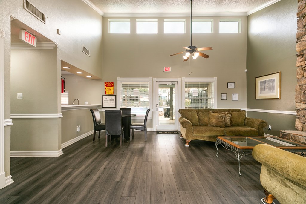 A living room with a brown couch and a dining table.