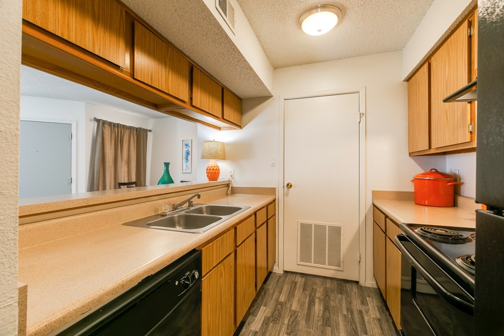 A kitchen with wooden cabinets and black appliances.