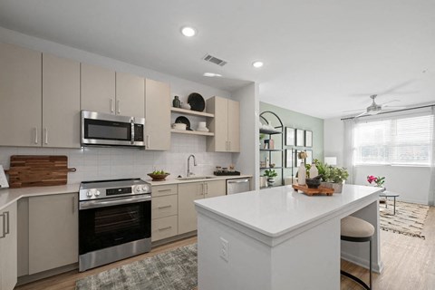 A modern kitchen with a large island and stainless steel appliances.