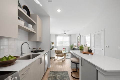 A modern kitchen with a white countertop and stainless steel appliances.