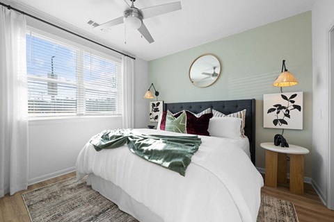 A bedroom with a large bed and a ceiling fan.
