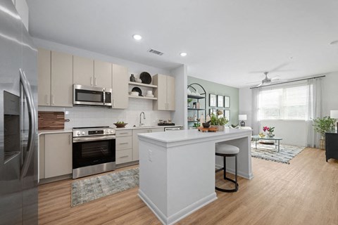 A modern kitchen with a center island and stainless steel appliances.