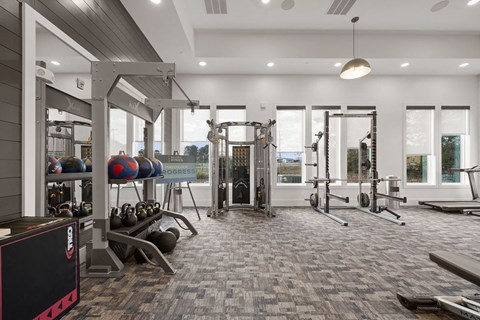 A gym with a variety of equipment including weights and machines.