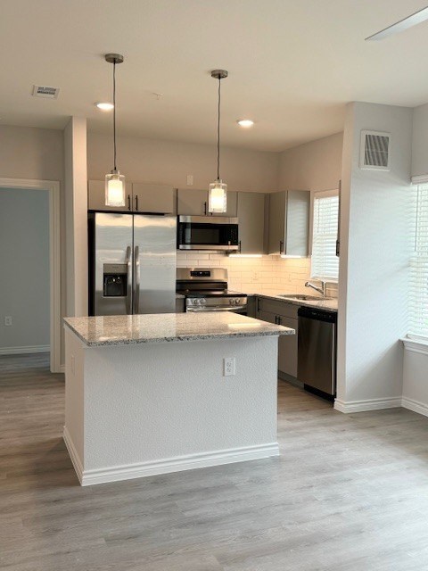 A kitchen with a granite countertop and stainless steel appliances.