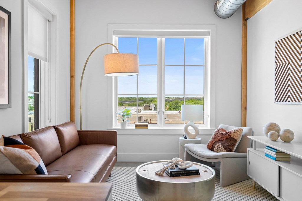 a living room with a large window and a leather couch