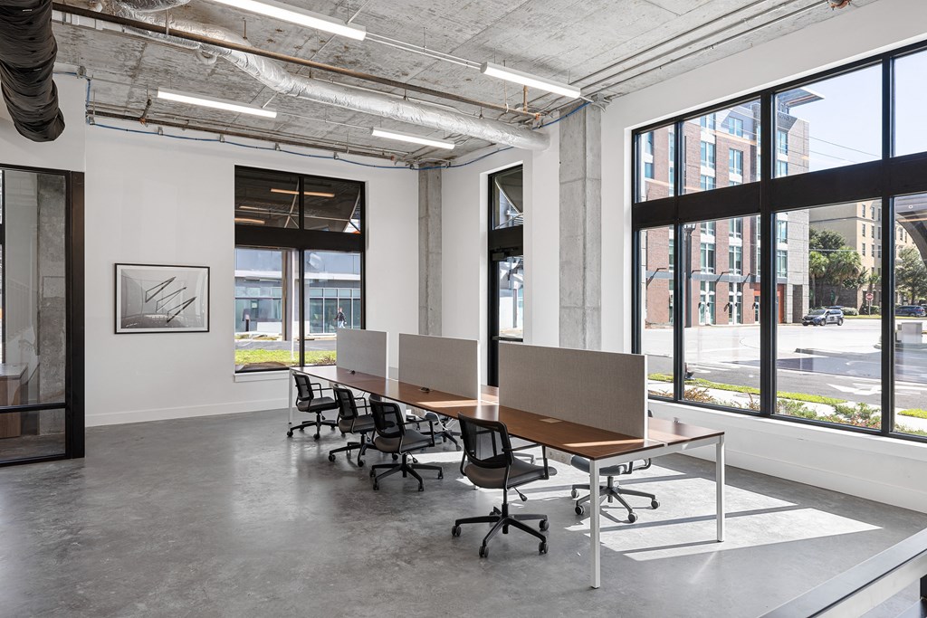a conference room with a long wooden table and chairs and large windows