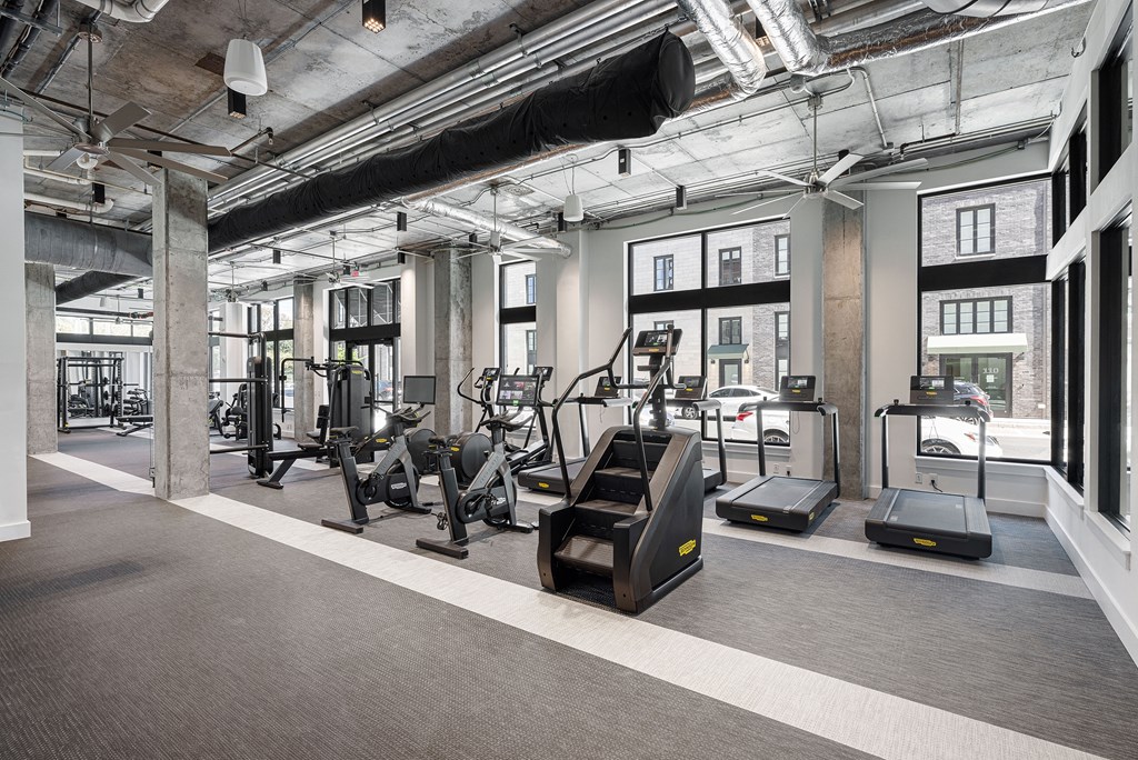 a gym with treadmills and other exercise equipment in a loft