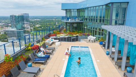 a swimming pool on the top of a building with people in it