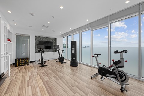 a gym with floor to ceiling windows and a view of the ocean
