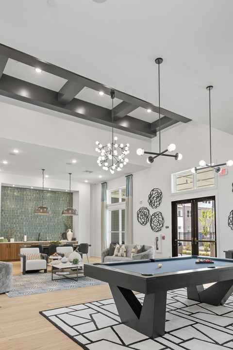 A pool table is in the middle of a room with a black and white rug.
