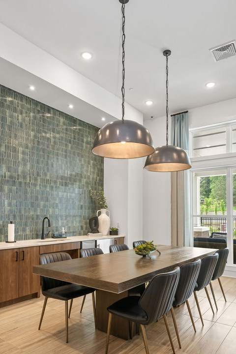 A modern dining room with a large table and chairs.