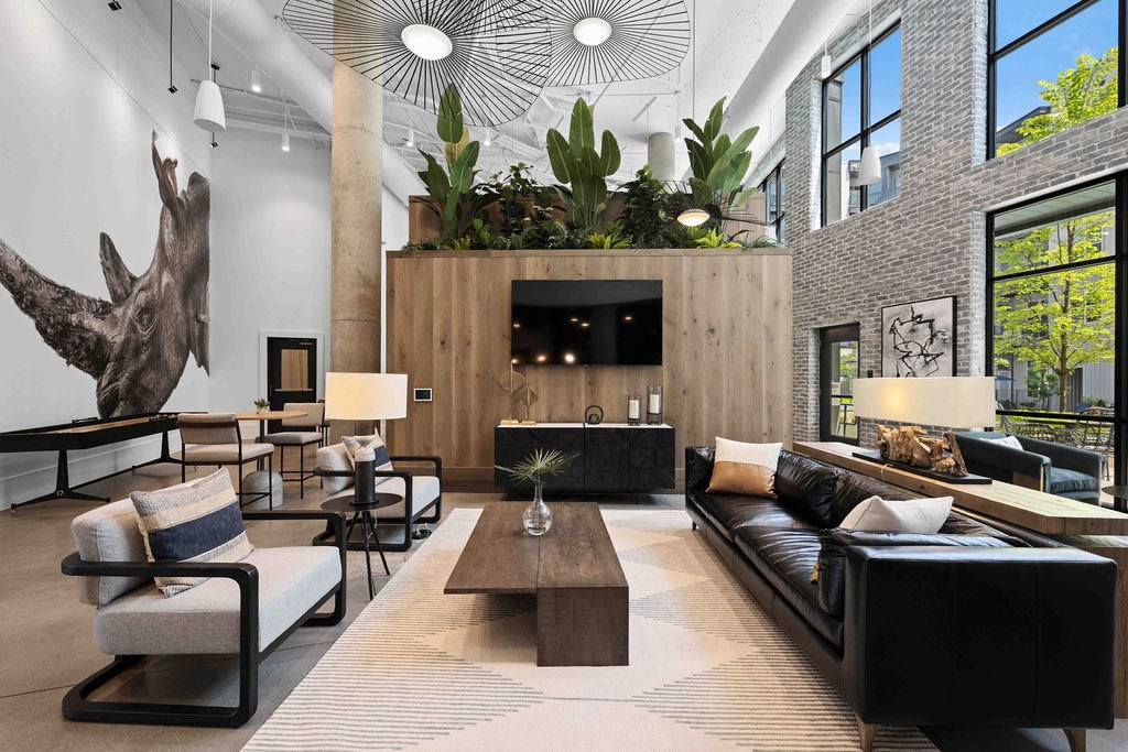 A living room with a large sofa, a coffee table, and a mounted TV.