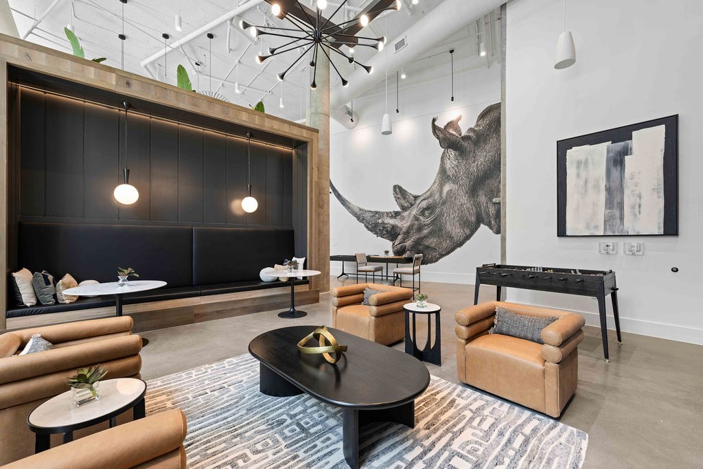 A living room with a large rhino head on the wall.