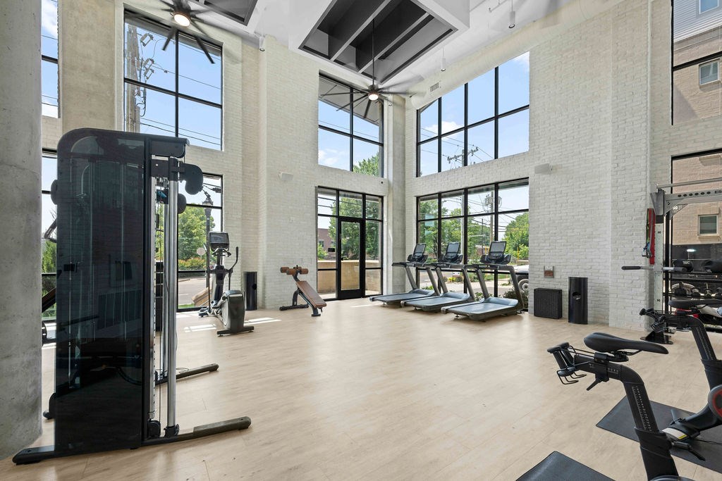 A gym with treadmills, elliptical machines, and a weight rack.