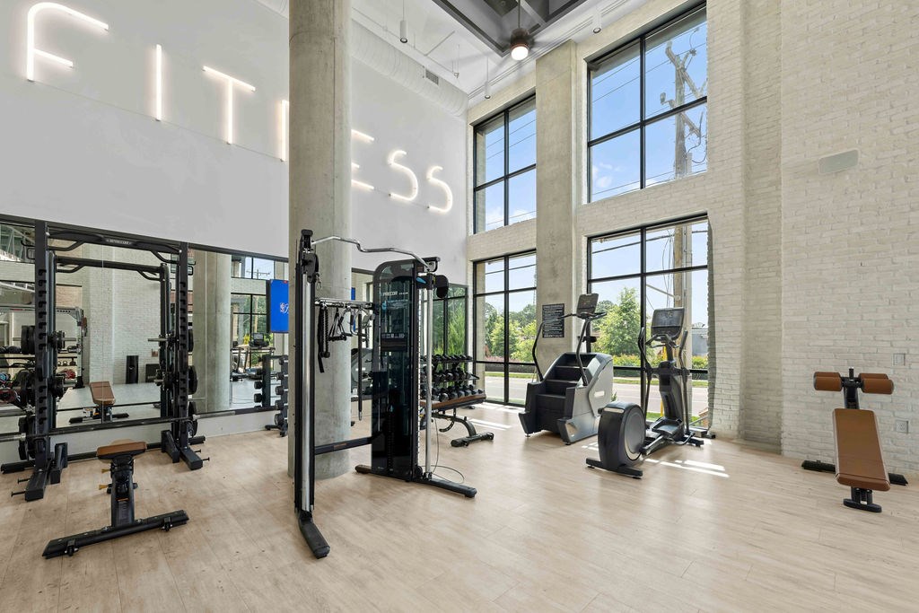 A gym with a variety of equipment including treadmills, weights, and exercise machines.