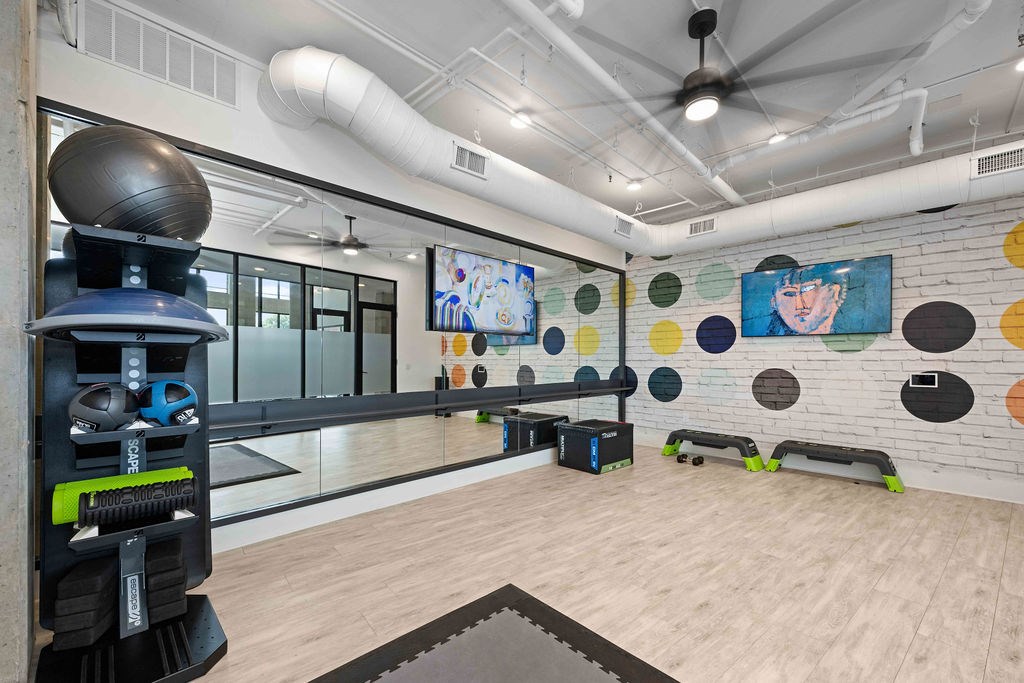 A gym with a variety of equipment including a balance trainer, a rowing machine and a bench.