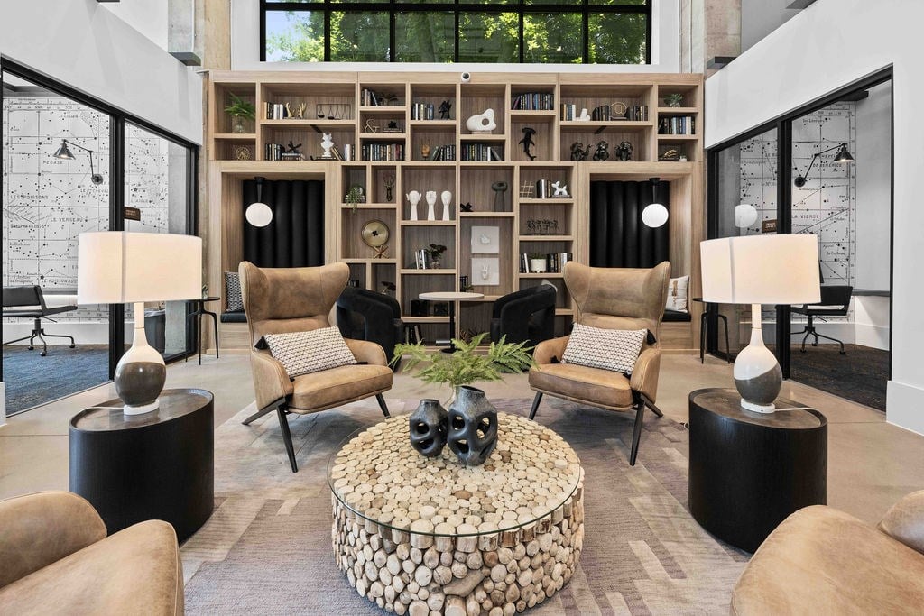 A living room with a stone coffee table and a bookshelf filled with books.