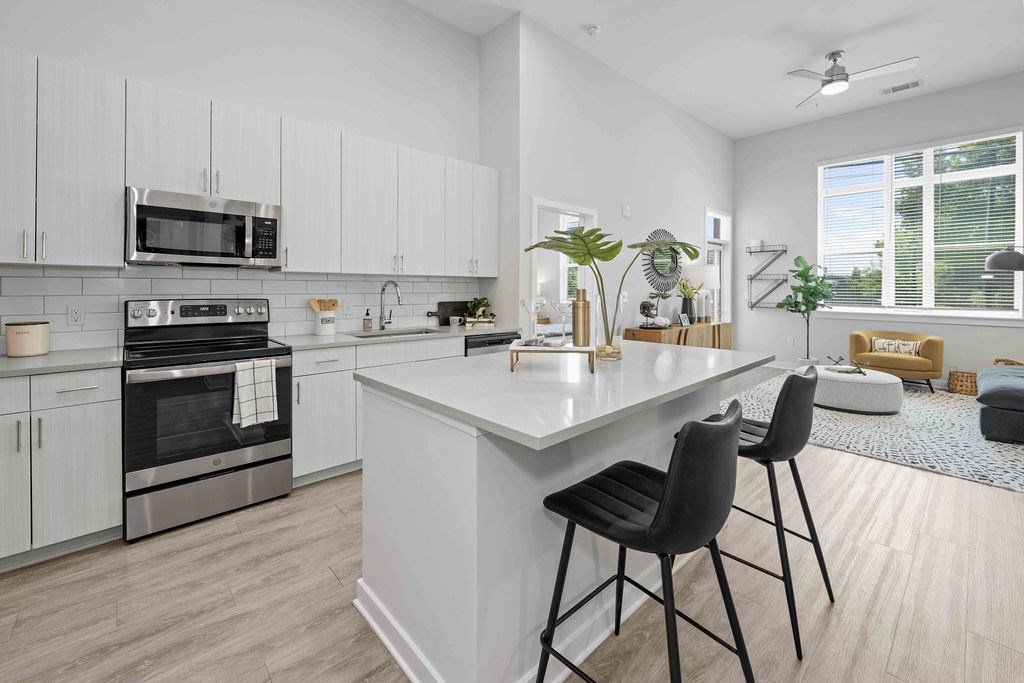 A modern kitchen with white cabinets and a large island.