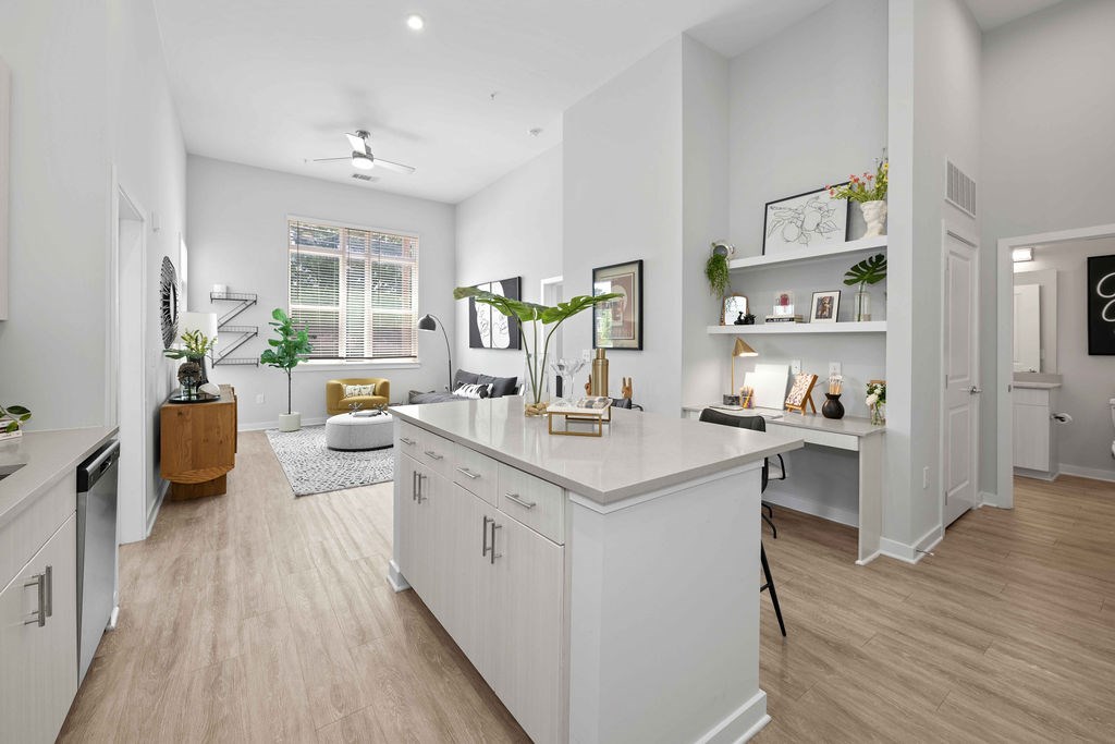 A well-lit, modern kitchen with white cabinets and a wooden floor.