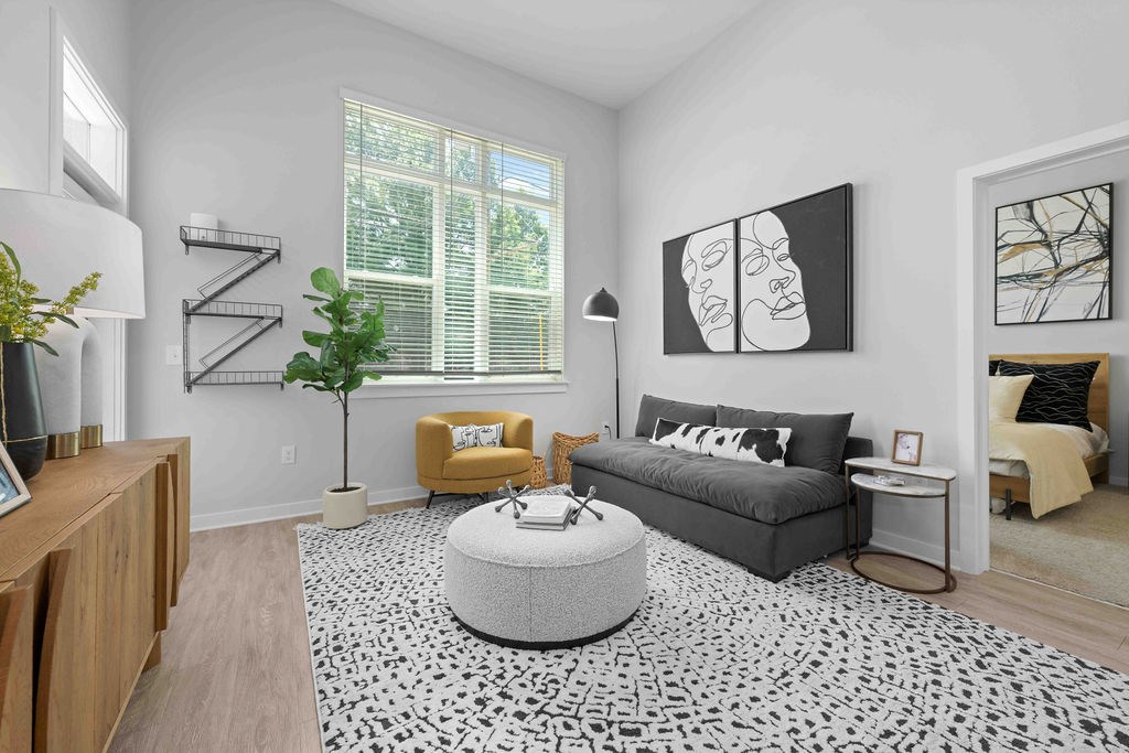 A living room with a grey sofa, yellow armchair, and a black and white patterned rug.