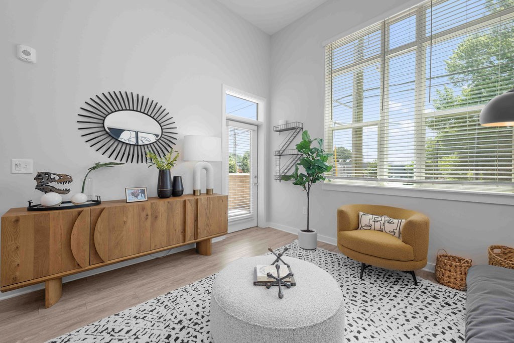 A living room with a yellow chair and a white rug.