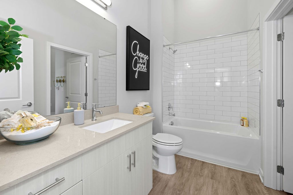 A bathroom with a white toilet and a white bathtub.